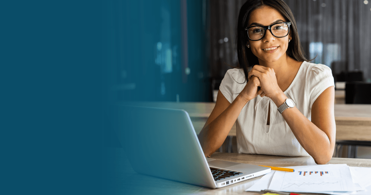 A female law expert smiling in front of her laptop.